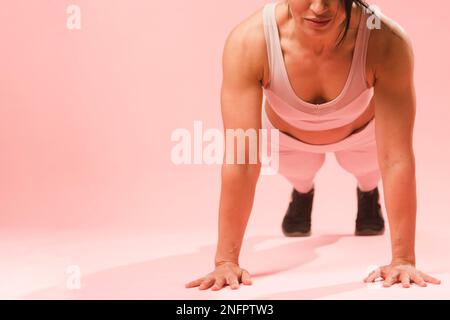 Athletische Frau tut Push-up Stockfoto