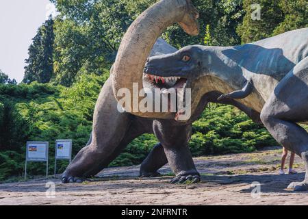 Statuen des Tyrannosaurus und des Nemegtosaurus im Dinosauriertal im schlesischen Zoologischen Garten, der Stadt Chorzow, der Region Schlesien in Polen Stockfoto