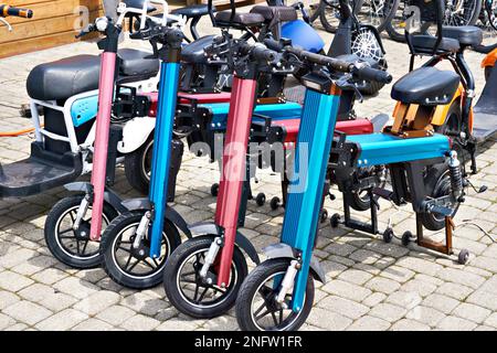 Elektrische Roller können auf dem Parkplatz gemietet werden Stockfoto