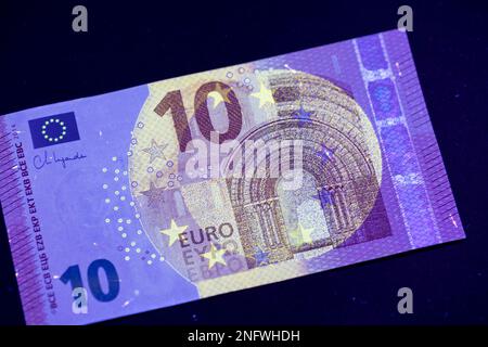 Euro-Währung im UV-Lichtschutz. Euro im UV-Licht, um die Echtheit des Geldes zu prüfen. Stockfoto