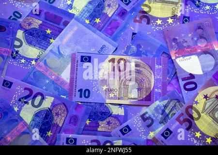 Euro-Währung im UV-Lichtschutz. Euro im UV-Licht, um die Echtheit des Geldes zu prüfen. Stockfoto