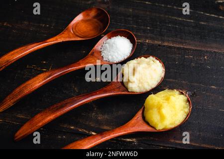 Ingwer-Knoblauch-Sauce Zutaten in Holzlöffeln: Pürierter Ingwer und Knoblauch mit Salz und Speiseöl Stockfoto