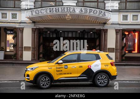 Moskau, Russland. 17. Februar 2023. Ein Yandex-Taxi wartet am Eingang zum Royal Aurora Hotel (Marriott-Kette) auf der Petrovka-Straße im Zentrum von Moskau, Russland Stockfoto