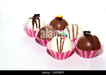 Set aus Schokoladenbomben, Marshmallow-Füllung und weißer Schokolade auf weißem Hintergrund Stockfoto
