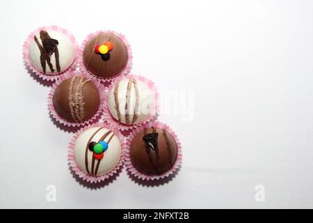 Set aus Schokoladenbomben, Marshmallow-Füllung und weißer Schokolade auf weißem Hintergrund Stockfoto