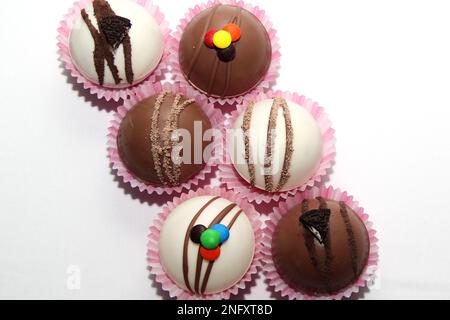 Set aus Schokoladenbomben, Marshmallow-Füllung und weißer Schokolade auf weißem Hintergrund Stockfoto