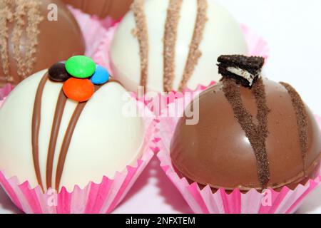 Set aus Schokoladenbomben, Marshmallow-Füllung und weißer Schokolade auf weißem Hintergrund Stockfoto