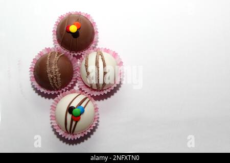 Set aus Schokoladenbomben, Marshmallow-Füllung und weißer Schokolade auf weißem Hintergrund Stockfoto