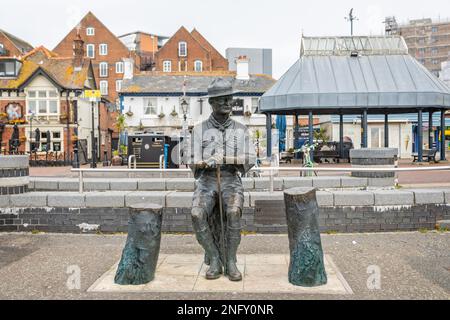 Bronzestatue von sitzendem Robert Baden-Powell, Gründer der Scouting-Bewegung, am 13. Februar 2023 am Quay, Poole, Dorset, Großbritannien Stockfoto