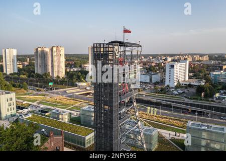 Turm of Shaft im Neuschlesischen Museum in der Gegend des ehemaligen Kohlebergwerks in Kattowitz, Polen, die Stars Apartments im Hintergrund Stockfoto