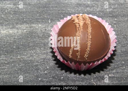 Set aus Schokoladenbomben, gefüllt mit Marshmallows und weißer Schokolade auf altgrauem Hintergrund Stockfoto