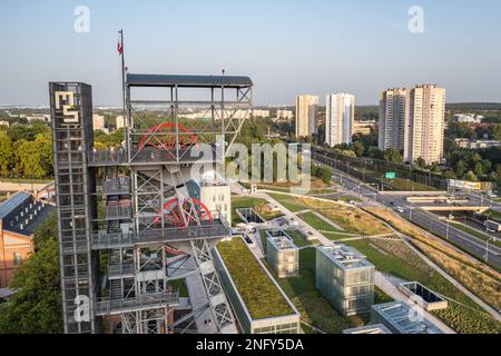 Turm of Shaft im Neuschlesischen Museum in der Gegend des ehemaligen Kohlebergwerks in Kattowitz, Polen, die Stars Apartments im Hintergrund Stockfoto