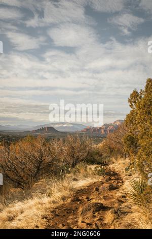 Wanderweg am beliebten Airport Mesa Loop Hike in Sedona, Arizona, USA, im Südwesten während des Tages mit wunderschönen Wolken am Himmel mit Blick nach Westen. Stockfoto