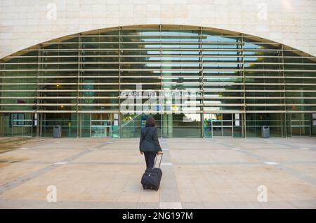 Elegante Frau mit ihrem Koffer vor dem Eisenbahnstadion in Monte Carlo, Monaco. Stockfoto