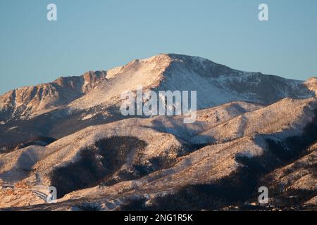 Alpenglow und Sonnenaufgang auf dem Pikes Peak, nach einem Wintersturm. Der Pikes Peak ist 14 m hoch und ragt über Colorado Springs, Colorado. Er ist 100 m hoch. Stockfoto