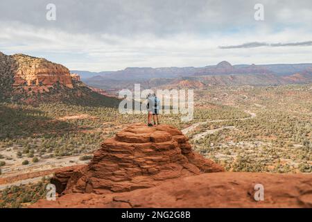 Junge heterosexuelle Paare, die sich auf dem Bell Rock mit Armen umarmen und einen tollen Blick im coconino National Forest in Sedona, Arizona, bieten Stockfoto