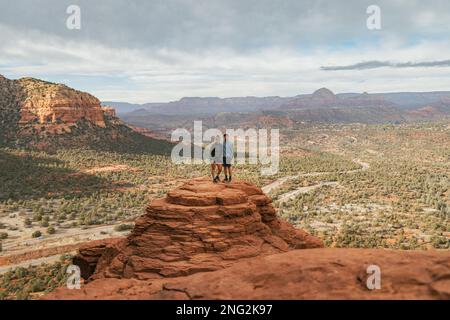 Junge heterosexuelle Paare, die sich auf dem Bell Rock mit Armen umarmen und einen tollen Blick im coconino National Forest in Sedona, Arizona, bieten Stockfoto