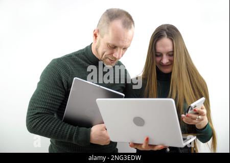 Zwei Softwareentwickler analysieren den Quellcode und betrachten dabei das Green Screen Chroma Key Mockup mit einem Kollegen, der am Schreibtisch sitzt und einen Schreibalgorithmus erstellt. Softwareentwickler, die an einem Projekt für künstliche Intelligenz arbeiten Stockfoto