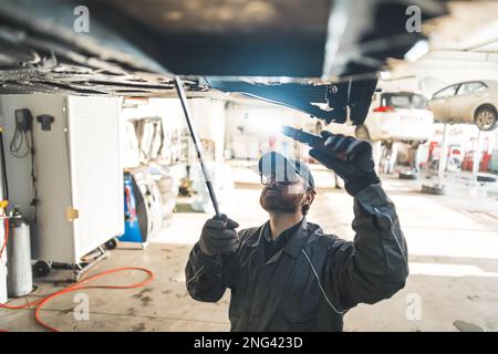 Aufnahme aus einem großen Winkel einer mechanischen Beleuchtung und Inspektion eines Fahrzeugrahmens. Hochwertiges Foto Stockfoto