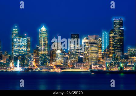 Seattle Skyline bei Sonnenuntergang Dämmerung entlang der Elliott Bay mit City Lights, Seattle, Washington, USA Stockfoto