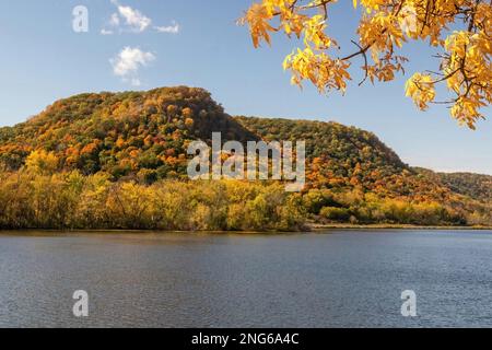 West Lake Winona mit seinen Klippen und Bäumen, die an einem sonnigen Herbsttag in Winona, Minnesota, USA, ihre Herbstfarben zeigen. Stockfoto