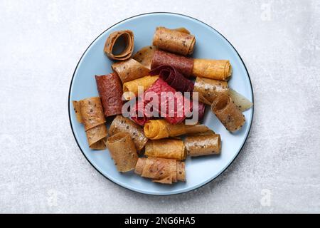 Köstliche Fruchtlederrollen auf einem grauen Tisch, Draufsicht Stockfoto