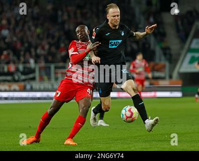 Augsburg, Deutschland. 17. Februar 2023. Kelvin Yeboah (L) aus Augsburg wehrt sich mit Kevin Vogt aus Hoffenheim während des deutschen Bundesliga-Fußballspiels in der ersten Division zwischen dem FC Augsburg und der TSG Hoffenheim in Augsburg, Deutschland, am 17. Februar 2023. Kredit: Philippe Ruiz/Xinhua/Alamy Live News Stockfoto