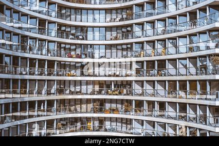 Eine verglaste Fassade eines weißen Hochhausgebäudes mit transparenten Balkongeländern und Fenstern in einem Muster; strukturierter Hotelhintergrund Stockfoto