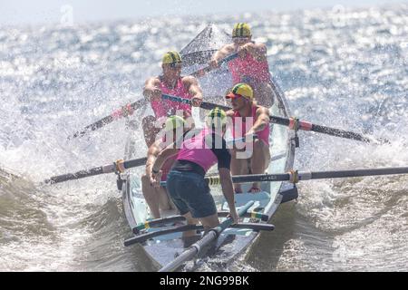 Australien Surfboat Racing Carnival am Collaroy Beach, Männerteam schleppt hart über ankommende Wellen zu Beginn des Surfbootrennen, Sydney, Australien Stockfoto