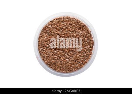 Leinsamen in weißer Schüssel, isoliert auf weißem Hintergrund. Draufsicht. Leinsamen. Hintergrund der Leinsamen-Textur. Stockfoto
