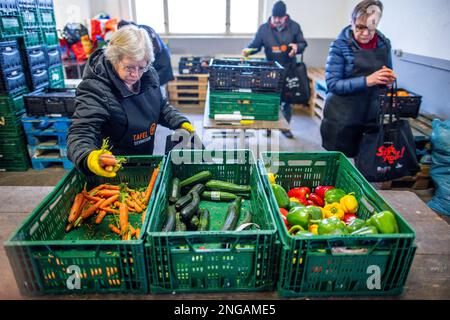 Schwerin, Deutschland. 16. Februar 2023. Freiwillige der Schweriner Lebensmittelbank prüfen, sortieren und verteilen die Lebensmittelspenden. Angesichts der derzeit hohen Inflation spielen die staatlichen Lebensmittelbanken eine besonders wichtige Rolle, wenn es darum geht, einkommensschwache Haushalte mit den grundlegenden Notwendigkeiten auszustatten. Kredit: Jens Büttner/dpa/Alamy Live News Stockfoto