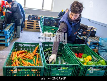 Schwerin, Deutschland. 16. Februar 2023. Freiwillige der Schweriner Lebensmittelbank prüfen, sortieren und verteilen die Lebensmittelspenden. Angesichts der derzeit hohen Inflation spielen die staatlichen Lebensmittelbanken eine besonders wichtige Rolle, wenn es darum geht, einkommensschwache Haushalte mit den grundlegenden Notwendigkeiten auszustatten. Kredit: Jens Büttner/dpa/Alamy Live News Stockfoto