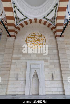 Bogenförmige Nischen mit modernem architektonischem Design im Innenhof der Camlica Moschee, Istanbul, Türkei. Text an der Wand übersetzt: Call on me, I will response to you. (Rufen Sie mich an, ich werde Ihnen antworten. Stockfoto