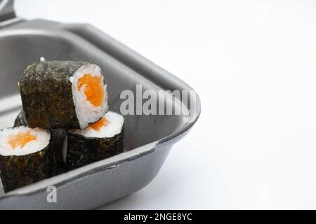 Plastikbehälter mit Sushi aus dem Restaurant auf isoliertem Hintergrund, Bestellung von Speisen zum Mitnehmen Stockfoto