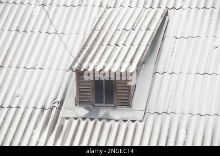Das Dach eines mehrstöckigen Gebäudes im Schnee im Winter am Nachmittag Stockfoto