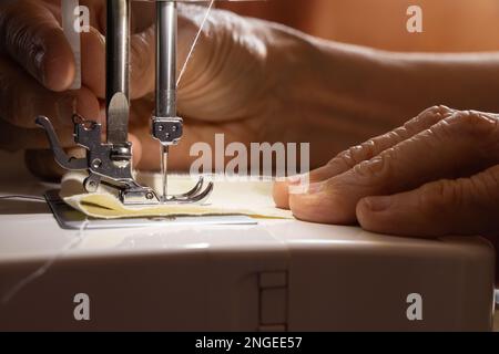 Nähmaschine und die Hand der alten Großmutter Stockfoto