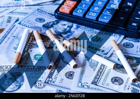 Konzept der Rauchkosten. Zigaretten auf einem Dollar-Hintergrund und schwarzen Rechner. Stockfoto