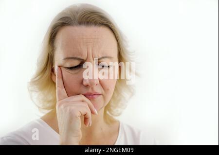 Unglückliche Frau, die Haare berührt, zu Hause auf dem Boden sitzt, über Probleme nachdenkt, aufgeregtes Mädchen, das sich einsam und traurig fühlt, psychische und psychische Probleme, leidet an einer schlechten Beziehung Stockfoto