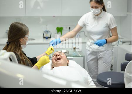 Eine Ärztin, eine Zahnärztin, behandelt die Zähne des Patienten, die richtige Zahnpflege. Zahnpflege und Hygienekonzept. Selektiver Fokus. Hochwertiges Foto Stockfoto
