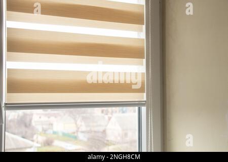 Beigefarbene Jalousien tagsüber nachts auf dem Küchenfenster aus der Nähe Stockfoto