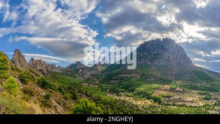 Berge und ein wunderschöner Himmel mit Sonnenstrahlen über dem Berg Puig Campana. Mount Castellet auf der linken Seite. Landschaft in Finestrat, in Stockfoto