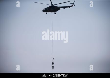 Kathmandu, Nepal. 18. Februar 2023. Die nepalesische Armee hält sich am Seil eines Hubschraubers fest und zeigt während des Armeetages eine Rettungsübung, die jährlich am Tag des Maha Shivarintosh Festivals im Armeepavillon in Kathmandu, Nepal, am Samstag, den 18. Februar 2023 stattfindet. (Kreditbild: © Skanda Gautam/ZUMA Press Wire) NUR REDAKTIONELLE VERWENDUNG! Nicht für den kommerziellen GEBRAUCH! Kredit: ZUMA Press, Inc./Alamy Live News Stockfoto