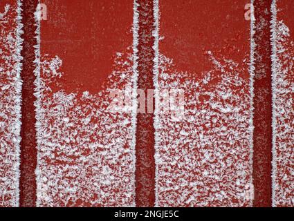 Hintergrundbild einer roten Holzwand mit Schnee oder Eis, Struktur oder Muster Stockfoto