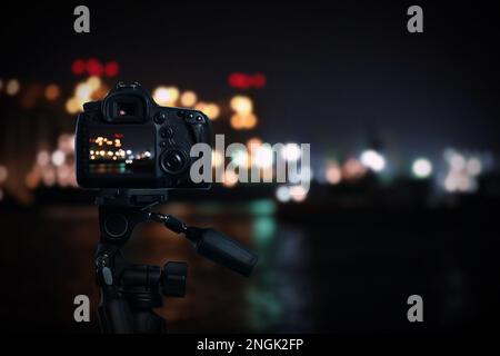 Fotografieren Sie die wunderschöne Stadtlandschaft bei Nacht mit der Kamera auf dem Stativ Stockfoto