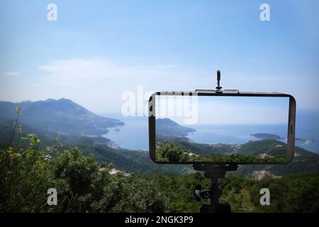 Fotografieren Sie die wunderschöne Berglandschaft mit dem auf dem Stativ montierten Smartphone Stockfoto