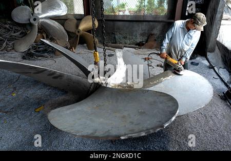 Arbeiter reparieren Propeller für Fischerboote in Rach Gia City, Kien Giang, Vietnam Stockfoto