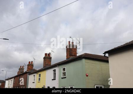 Eine Reihe traditioneller englischer Schornsteine und Häuser, Maldon, Essex. Gelb und grün bemalte Häuser. Stockfoto
