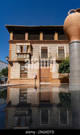 Ein Beispiel für den modernistischen Hausbau aus dem 20. Jahrhundert, der sich in einem kleinen Becken in Cuevas Bajas in der Provinz Málaga, Andalusien, Spanien, widerspiegelt Stockfoto