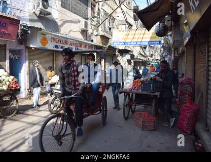 Ein Tuktuk mit einem männlichen Passagier, der in den engen Gassen von Alt-Delhi geritten wird Stockfoto