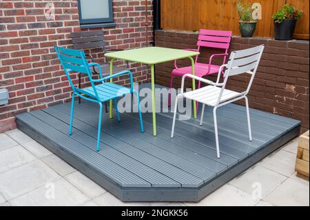 Neu erbaut und grau gestrichen mit farbenfrohen Möbeln Holzterrasse im hinteren Garten. Stockfoto